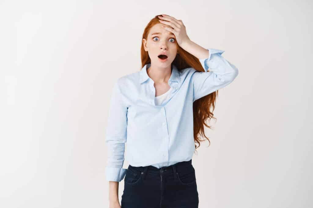 Shocked and worried redhead woman